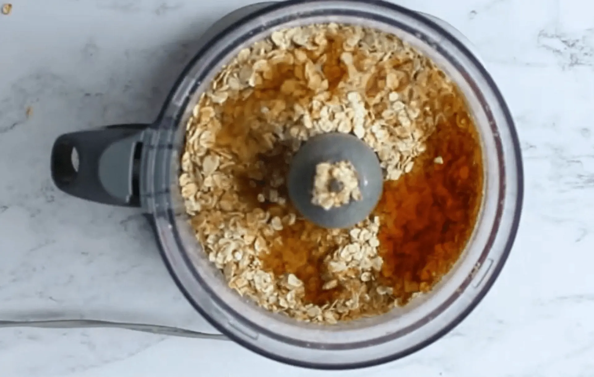 Oats and golden syrup in a food processor ready for a healthy homemade flapjack
